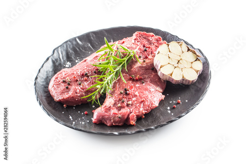 Beef meeat Rib-Eye steak wit rosemary salt and pepper in black plate isolated on white