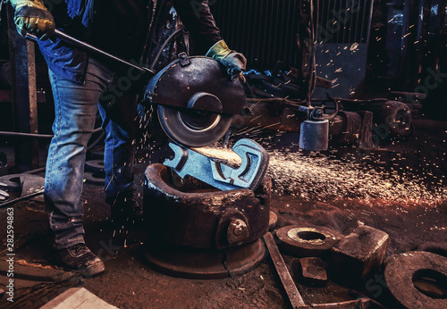 Worker cut metal with angle grinder