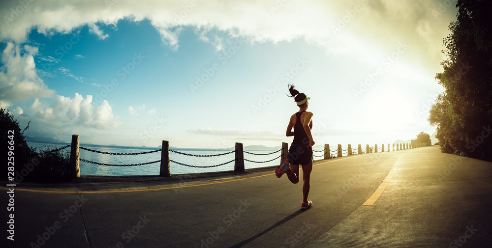 Fitness woman running on seaside trail in the morning - obrazy, fototapety, plakaty 