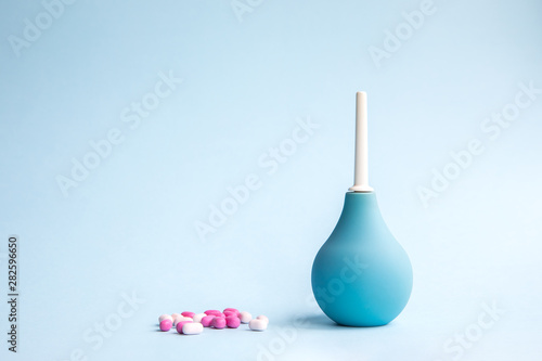 Obraz na plátně Blue douche and tablets of pink and white color on a blue background