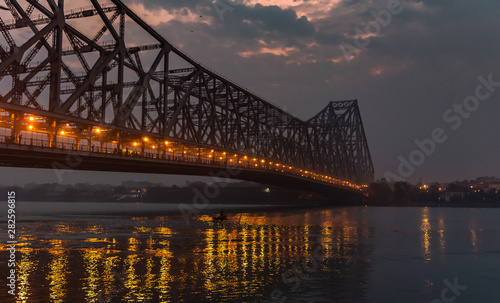 Silhouette of Howrah Bridge at the time of Sunrise. Howrah Bridge is a bridge with a suspended span over the Hooghly River in West Bengal.