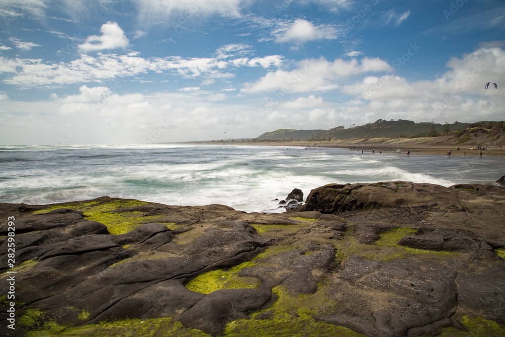 A view down the dramatic and wild Muriwai Beach taken from across rocks. A view down the dramatic and wild Muriwai Beach taken from across rocks.