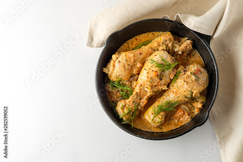 Spicy chicken in a sauce in a frying pan. top view from above
