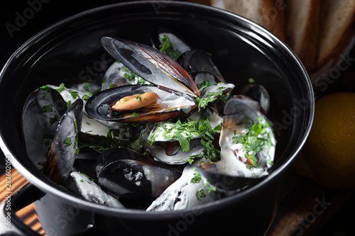 Boiled mussels with a sauce in a black pan