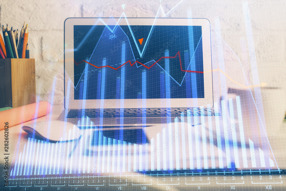Financial chart drawing and table with computer on background. Multi exposure. Concept of international markets. Financial chart drawing and table with computer on background. Multi exposure. Concept of international markets.
