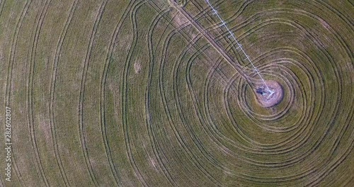 Flying, overhead shot of a crop circle with a slow pan up to the horizon. photo