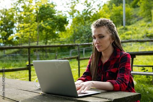 Young woman working outdoors on her laptop