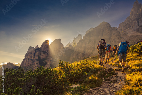 Fotografia Some hikers go up a mountain path in the early hours of the day
