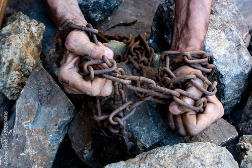 The hands of a slave in an attempt to release. The symbol of slave labor. Hands in chains