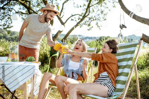 Photography Young friends having fun, drinking juice at the beautifully decorated yard with