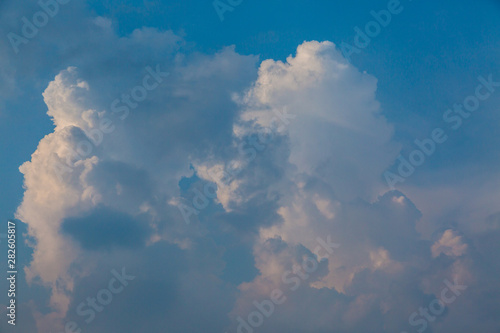 white cumulus cloud banked up, blue sky