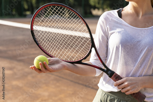 Close-up woman holding tennis ball © Freepik