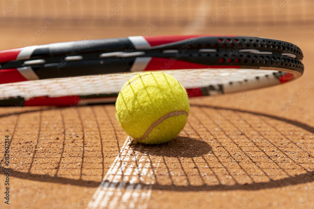 Close-up tennis racket over ball