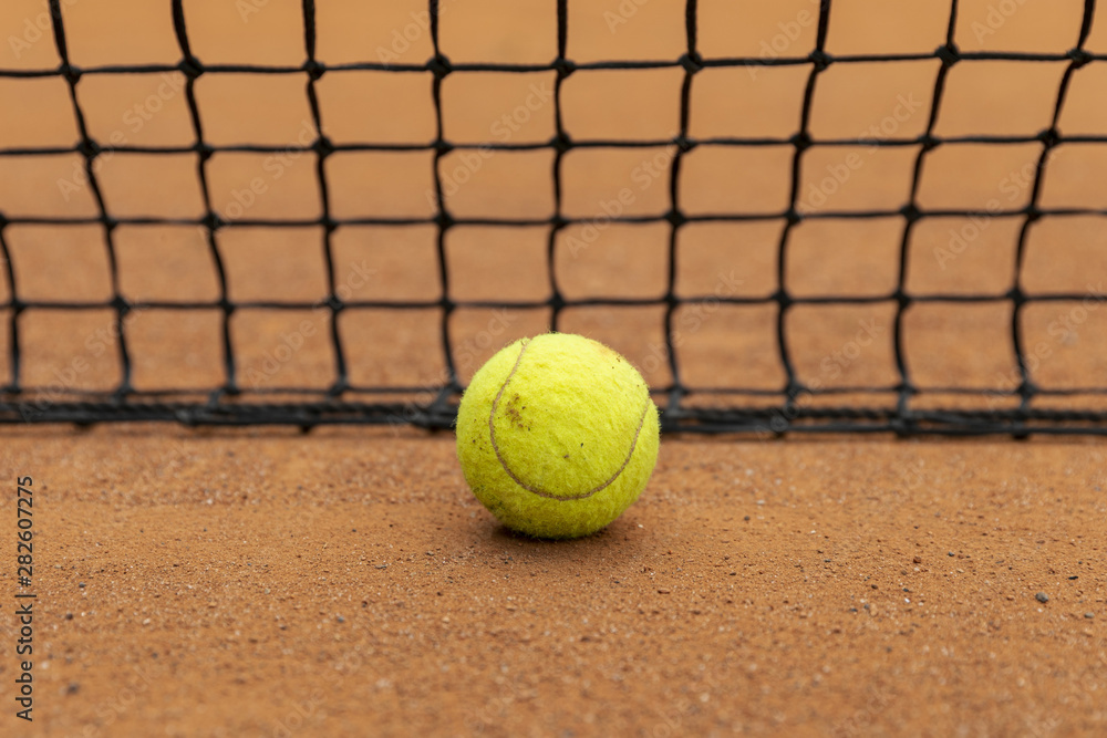 Close-up tennis ball next to net