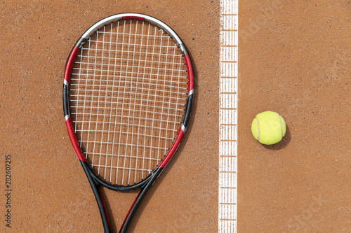 Top view racket and tennis ball on court ground © Freepik