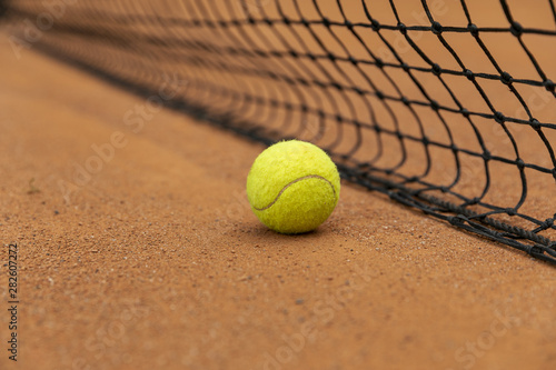 Close-up tennis ball next to net