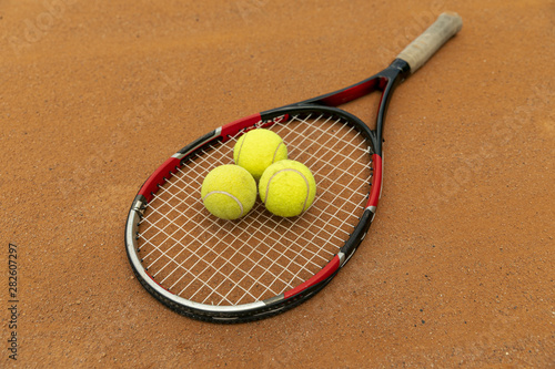 High view racket and tennis balls on court ground © Freepik
