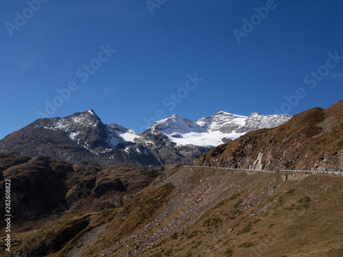 Road going up the Passeo del Bermina, Switzerland, with snowy peaks and sparse vegetation © John