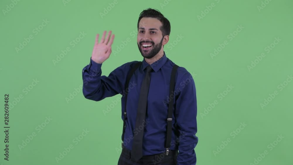 Happy young bearded Persian businessman waving hand Happy young bearded Persian businessman waving hand
