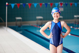 Portrait Of Girl Standing By Edge Of Swimming Pool Ready For Lesson