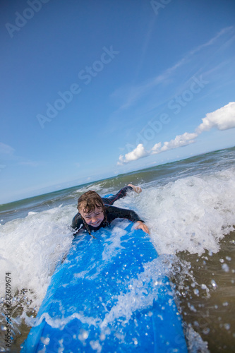 Little boy learning to surf at the beach, getting up on surfboard for the first time, west coast of Ireland © Gabriel Cassan