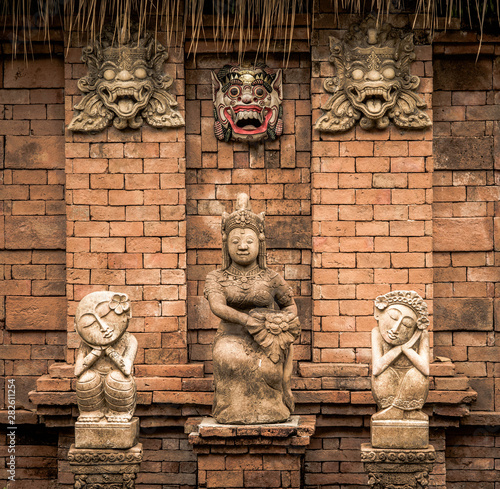 Ancient statues on a background a stone wall in Thailand.