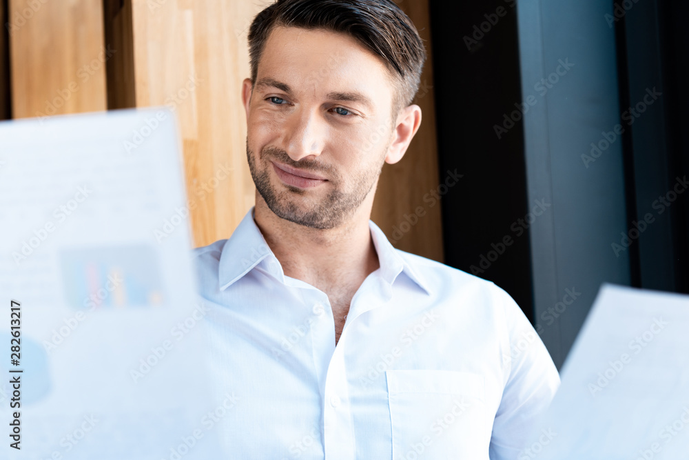 focused man looking at documents with gently smile in cafe focused man looking at documents with gently smile in cafe