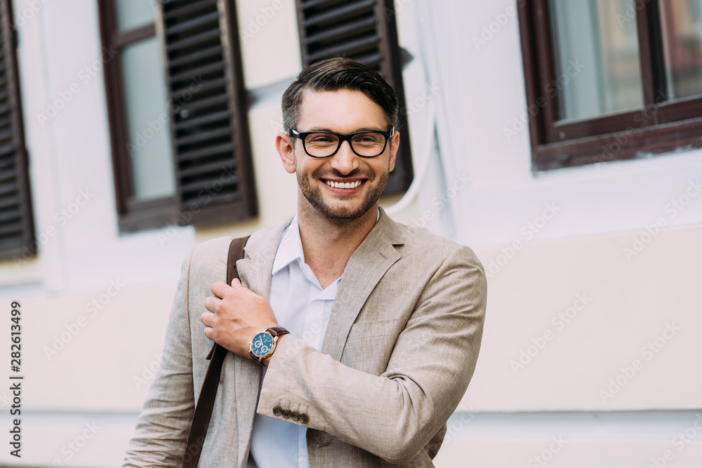 smiling businessman in glasses and wristwatch on street smiling businessman in glasses and wristwatch on street