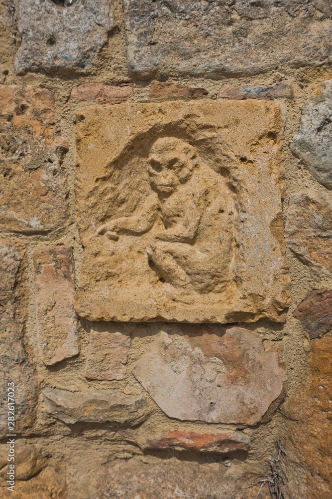 Artistic and architectural details on a wall at Volterra, Tuscany, Italy