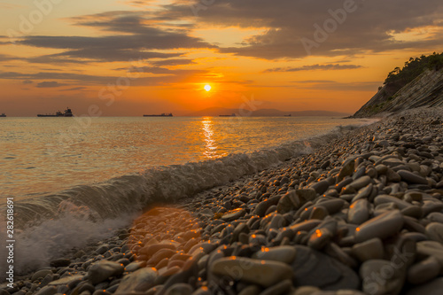 Bright sunset with small yellow sun under the sea surface © яна винникова