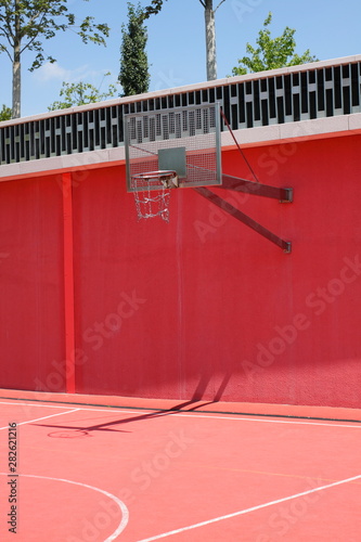 Street ball on the outdoor red basketball playground.  photo