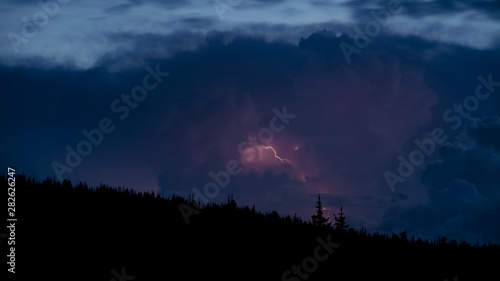 night sky with clouds and thunderstorm behind the clouds