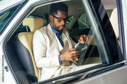 afro business male talking on phone with smile on face and useing route novator app