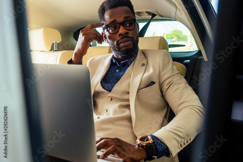 business afro male useing phone route novator map app sitting in car photo