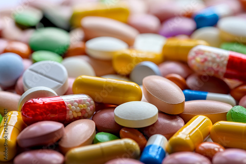 Close up of variety of colorful pills, capsules, and tablets photo