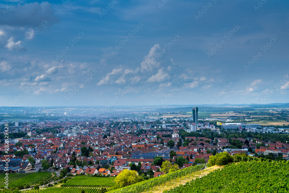 Germany, Fellbach city houses and roofs from above kappelberg vineyards in summer while rain going down over the city centre
