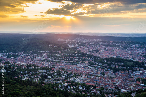 Germany  Endless aerial view above roofs and houses of city stuttgart in basin surrounded by green forest at sunset