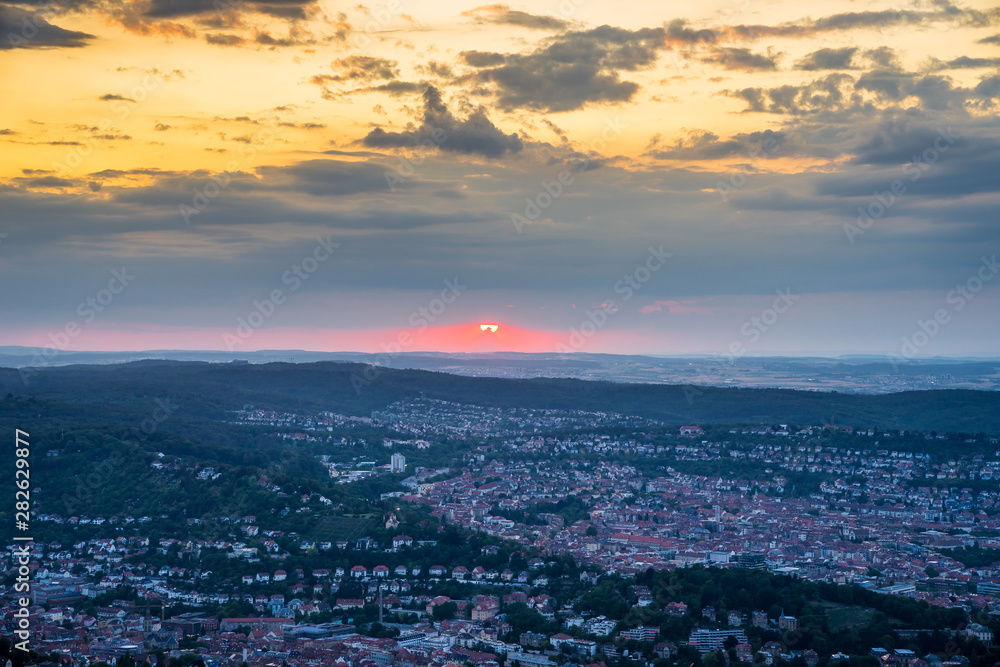 Germany, Red sky at sunset in summer over cityscape of city stuttgart, aerial perspective above houses, roofs and buildings