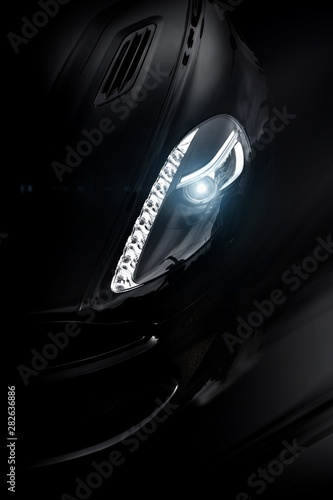 Closeup shot of the front lights of a powerful modern supercar photo