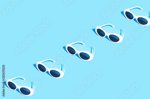 White sunglasses pattern on pastel blue background.