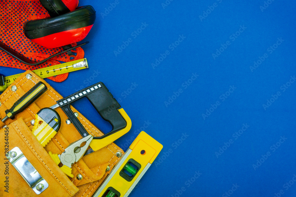Professional tools in the bag for the joiner and spare parts on a blue background.