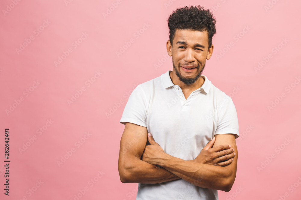 Obraz premium A young sad shocked funny African American male isolated against pink background.