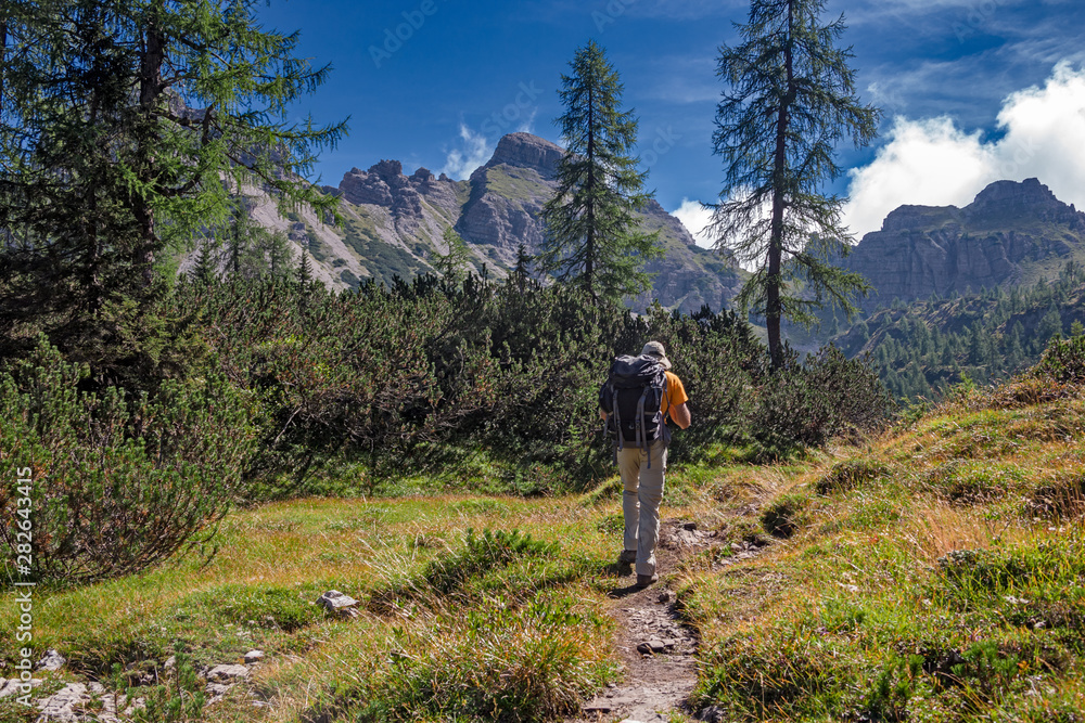 A hiker walks along a path in the Friulian Dolomites, in Italy