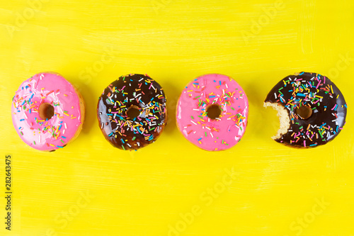 Canvas Print Sweet donuts with icing on yellow background