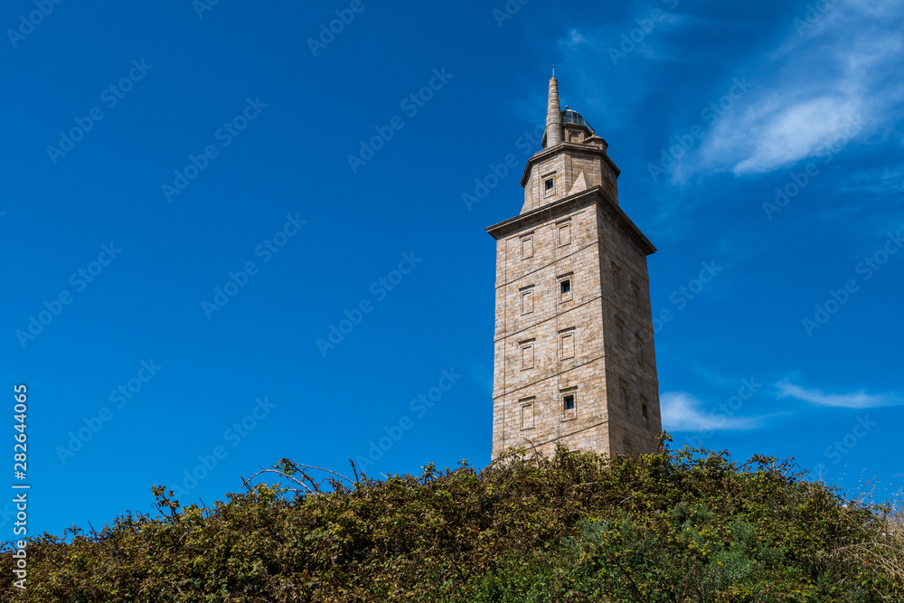 View of the Tower of Hercules, in A Coruna, during a hot summer day. An ancient Roman lighthouse, the second-tallest lighthouse in Spain, National Monument and UNESCO World Heritage Site