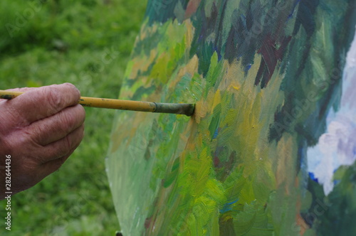 Drawing oil paintings of a natural landscape on a white cardboard