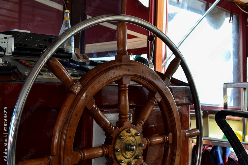 Wood steering wheel of a cruise ship. Close-up.