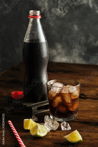Canvas Print Glass with ice and fizzy beverage and bottle with carbonated drink