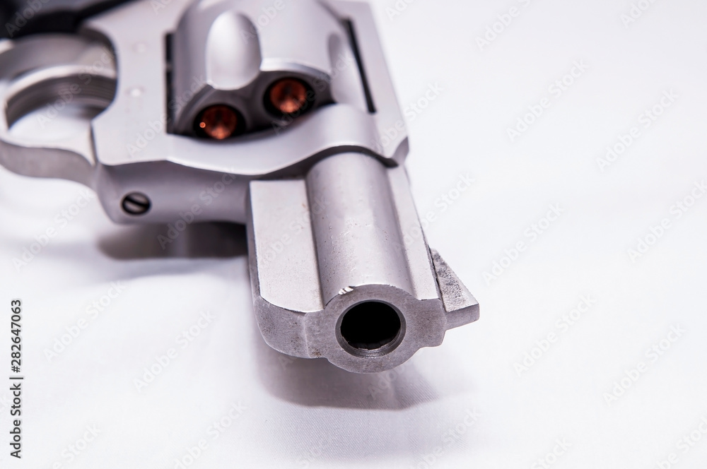 A 357 magnum snub nosed revolver loaded with hollow point bullets on a white background