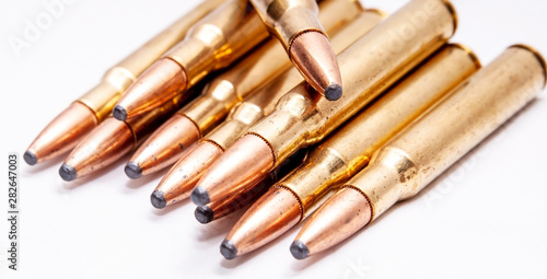 A close up of brass rifle bullets used for hunting on a white background